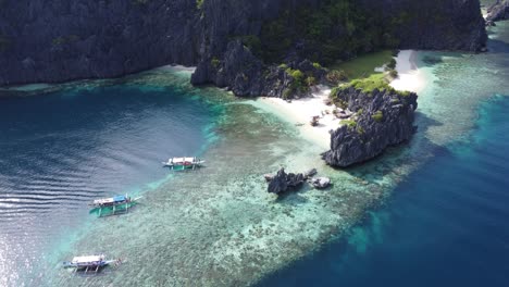 Tourist-boats-anchored-at-the-reef-of-Star-Beach-on-Tapiutan-Island,-El-Nido---Philippines