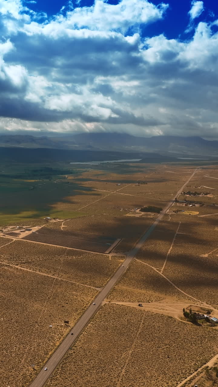 Fantastic cloudscape hanging over the desert and throwing shadows on the land. Beautiful scenery of Nevada desert from aerial view. Vertical video
