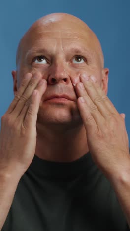 man applying facial cream or sunblock