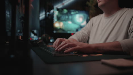 man working on computer in a dark studio