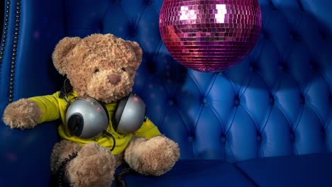 teddy bear dj in a blue velvet chair with disco ball