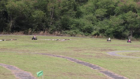 go-karts race on a grassy outdoor track