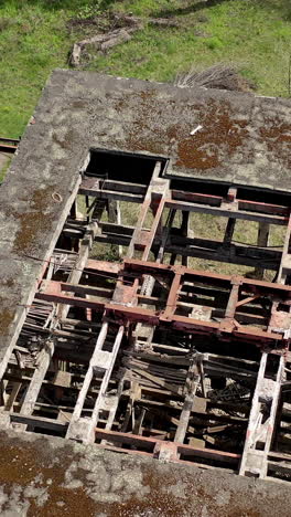 destroyed factory. abandoned ruined warehouse or production department on the factory territory. old industrial edifice without roof for demolition. aerial view. vertical video
