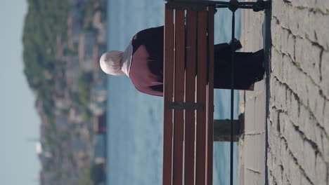 woman in hijab sitting on a bench by the water