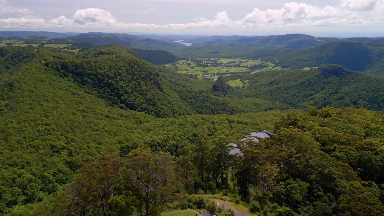 Expansive aerial drone footage of Binna Burra, highlighting the rugged mountain ranges, lush rainforest, and deep valleys of the Gold Coast Hinterland with stunning natural beauty.