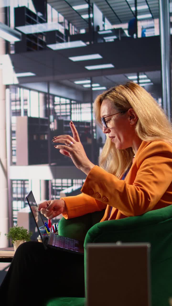 Professional Woman Engaged in Video Call on Laptop in Modern Office