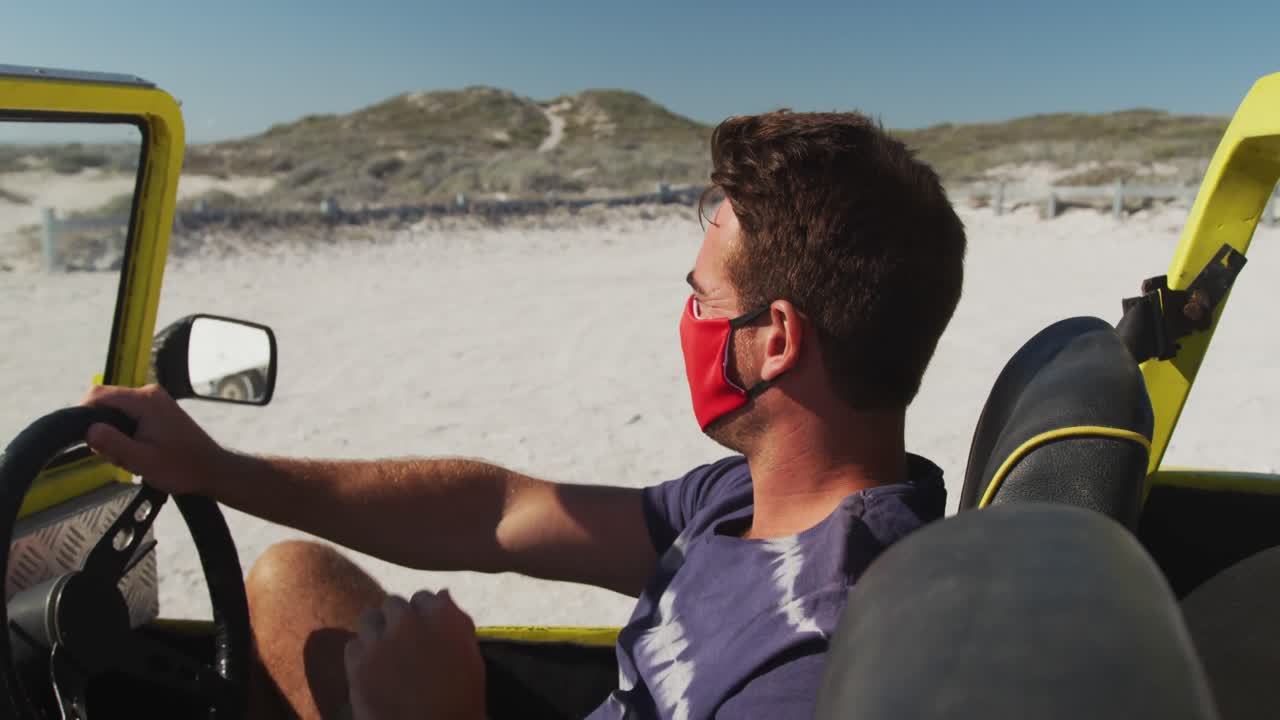 Caucasian man wearing face mask sitting in beach buggy