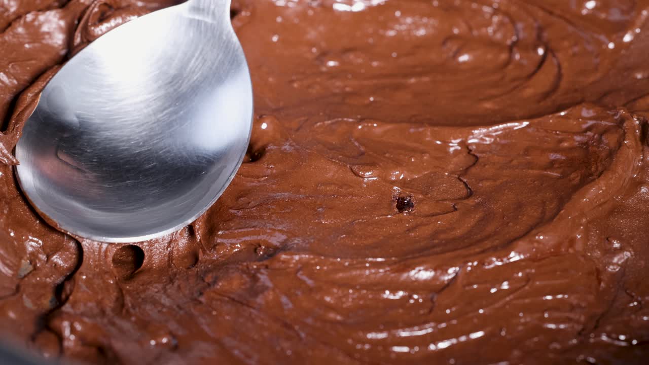 primer plano de la mezcla de chocolate derretido suave que se agita con cuchara