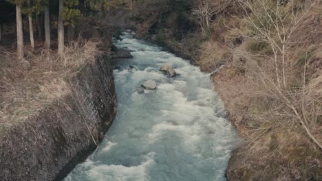 Río-Sho-Que-Fluye-En-El-Pueblo-De-Shirakawa-En-Gifu,-Japón