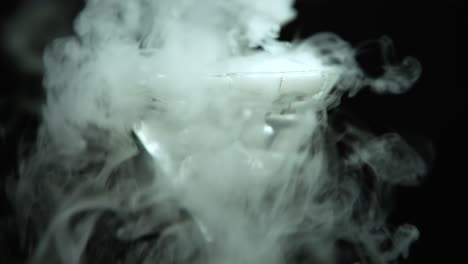 close up of a martini glass filled with ice and a whiskey glass