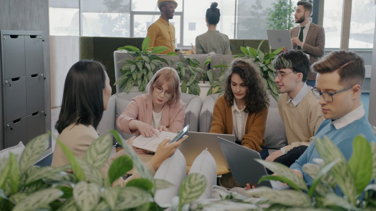 Diverse team in a modern office space during a casual meeting.