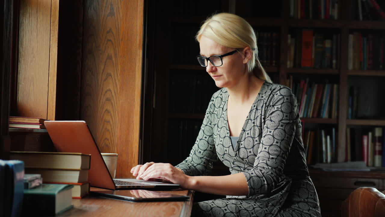 Kvinde arbejder med bærbar computer på bibliotek