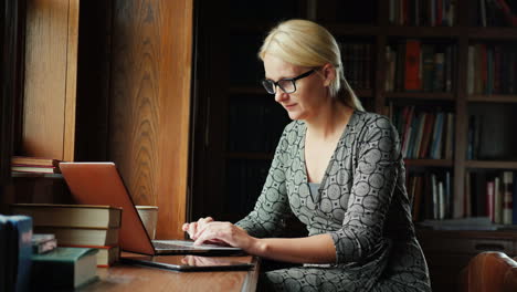 mujer trabaja con una laptop en la biblioteca