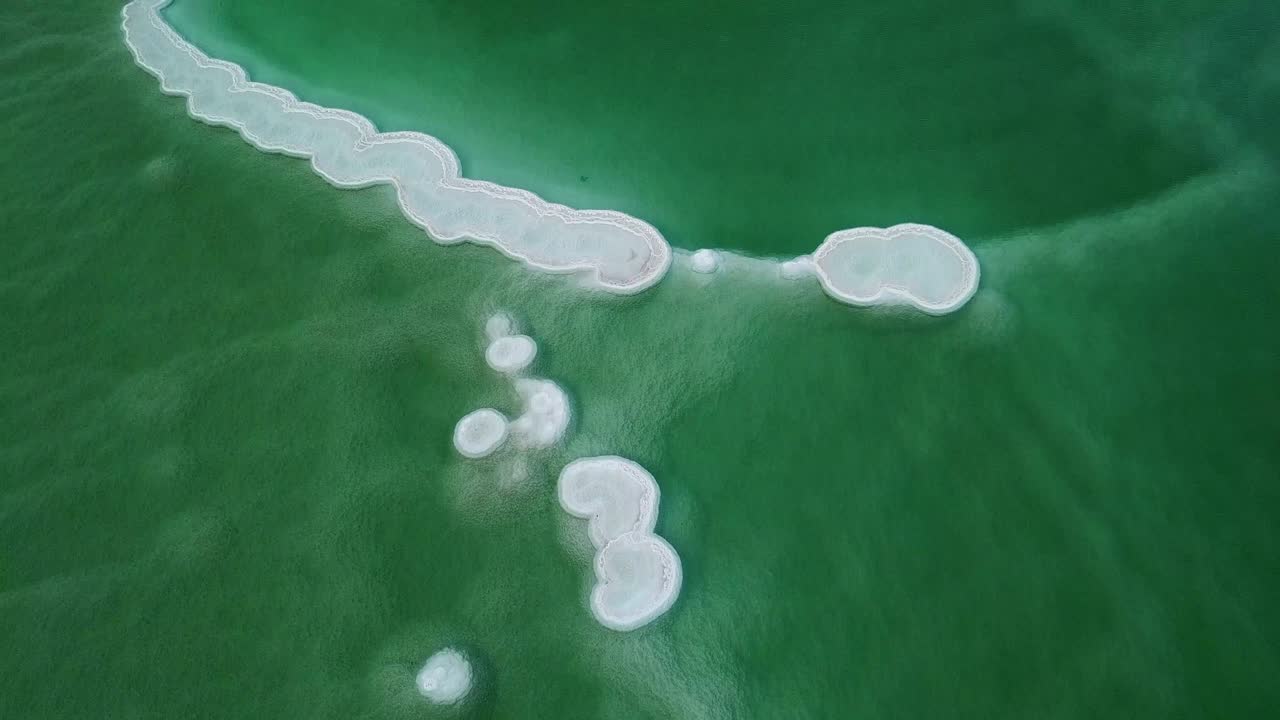 죽은 바다의 물 속에 있는 둥근 모양의 소금 퇴적물의 공중 사진, 이스라엘