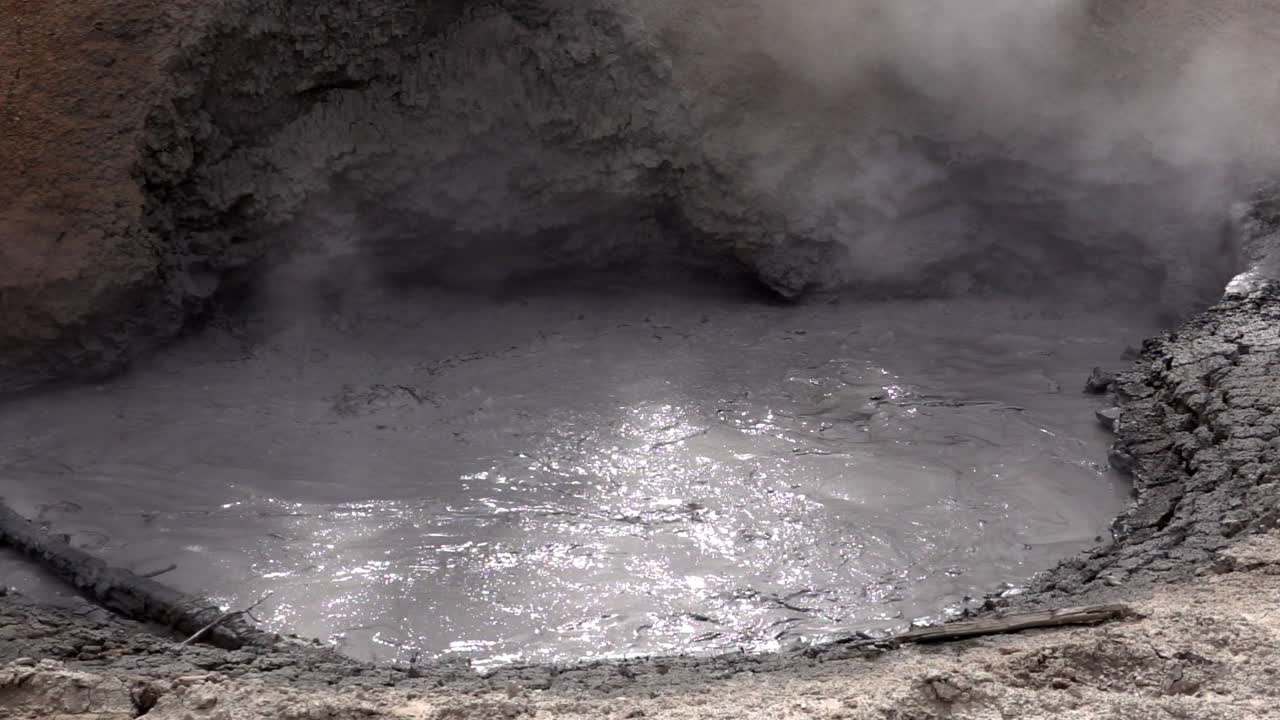 barro turbulento y vapor de una olla de barro geotérmico en cámara lenta, en el parque nacional de yellowstone