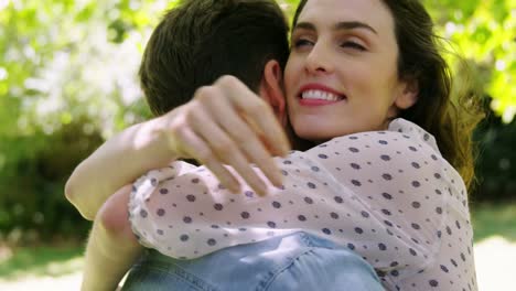 una pareja romántica abrazándose en el parque.