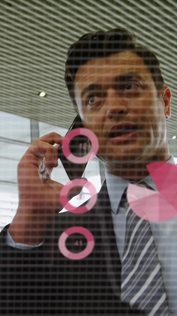 Animation of statistical data processing over caucasian businessman talking on smartphone at office