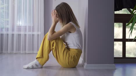 mujer deprimida llorando en el suelo.