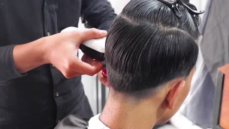 male client getting haircut by hairdresser