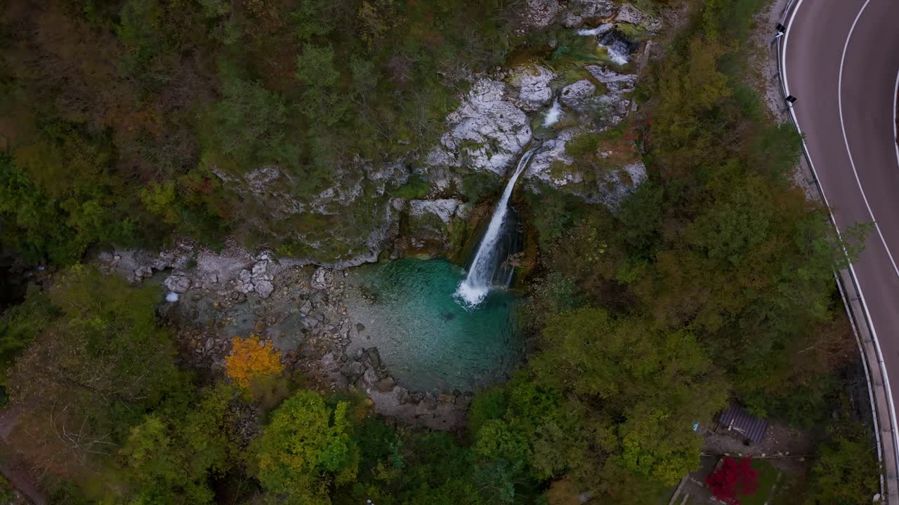 Un'immagine aerea di una cascata che mostra il turismo sostenibile e la bellezza naturale.