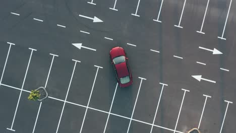 the red car leaves the empty parking lot