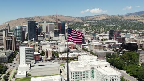 usa flag on downtown skyline salt lake city, utah building rooftop - aerial