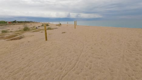 Coarse-sand-beach-sea-wave-in-slow-motion-at-120fps-4k-cloudy-day-turquoise-water-single-sea-waves-Big-empty-beach