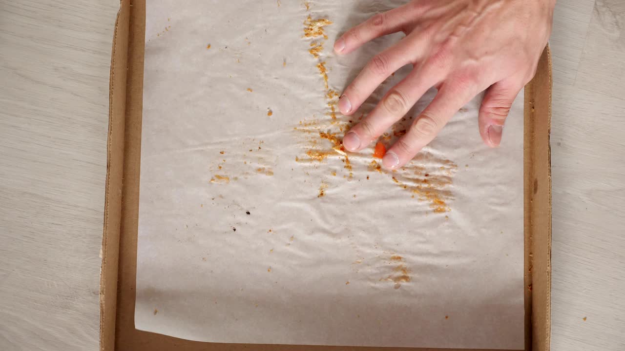 la mujer agarra la última rebanada de pizza y deja la caja de entrega vacía.