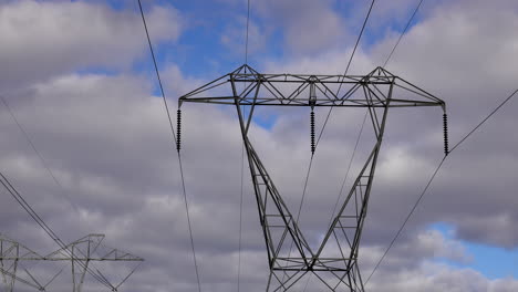 top part of electrical pylon with insulators and transmission lines