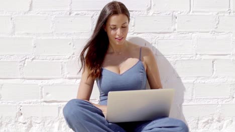 Young-woman-working-on-a-laptop-in-the-sunshine