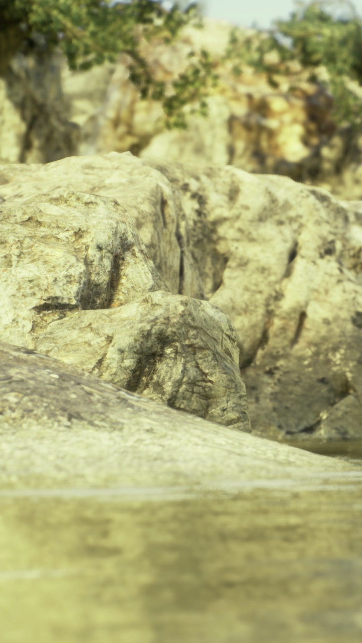 Scenic view of calm water reflecting rocky shoreline during bright daylight