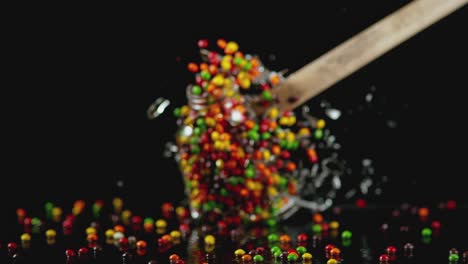 a mallet swings and hits a glass jar filled with candy