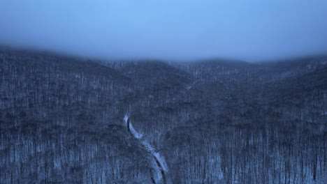 beautiful aerial drone video footage of the appalachian mountains covered in snow at night during evening