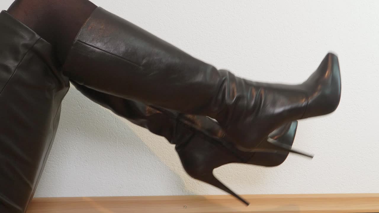 mujer sentada en el suelo con botas altas de plataforma negra se mueve alternativamente hacia arriba y hacia abajo