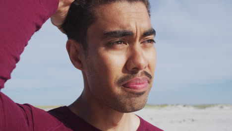 Retrato-Oh-Hombre-Hispano-Relajado-Parado-Bajo-El-Sol-Y-El-Viento-En-La-Playa