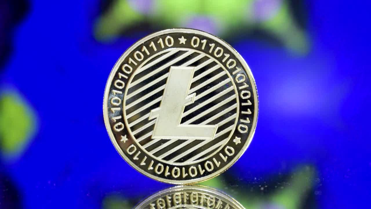 primer plano de una sola litecoin dorada en un suelo de espejo con un colorido fondo hipnótico