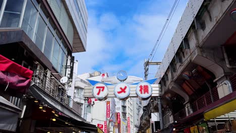 bustling tokyo street market under blue sky with shops and people walking by on a sunny day