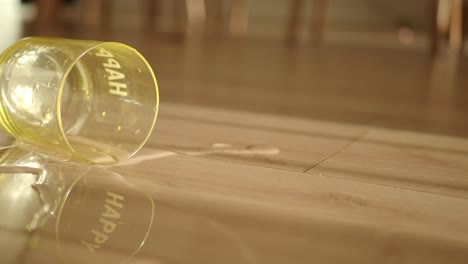 spilled water from a 'happy' glass on a wooden floor