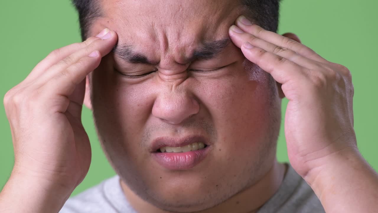 초록색 배경에 젊은 잘생긴 과체중 아시아인