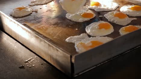 muchos huevos son fritos en un gran horno profesional en el restaurante del hotel.