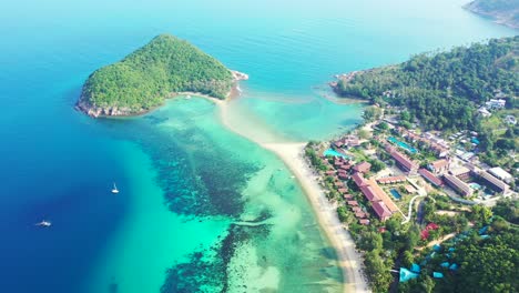 Paradise-vacations-resort-on-Thai-seaside-with-white-sandy-beach-and-calm-turquoise-lagoon-on-tropical-island-with-lush-vegetation,-Koh-Phangan