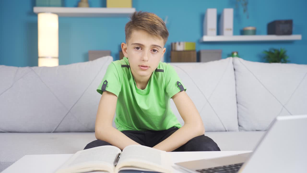 소년은 소파에 앉아 스트레스를 받고 카메라에 부정적인 고개를 끄덕인다.