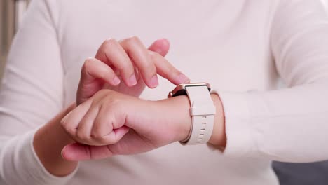 primer plano de una mano de mujer que toca y se desplaza en un reloj inteligente para verificar rápidamente la conexión de la aplicación