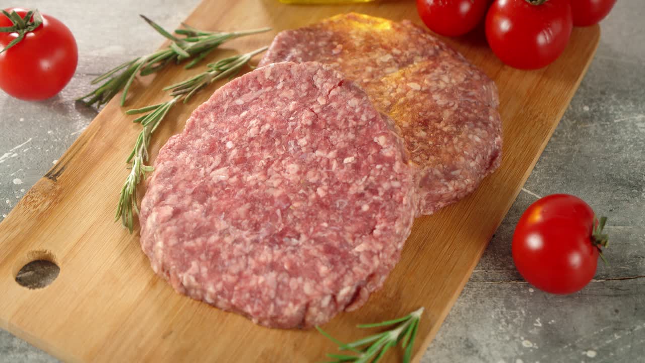 Raw burger meat on a wooden cutting board.