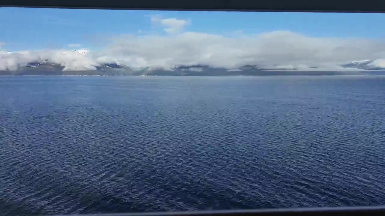 Alaska-Kreuzfahrt Zeitraffer direkt vom Balkon des Kreuzfahrtschiffs bei ruhiger See, Bergen und tiefen Wolken.