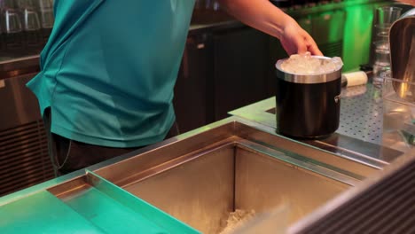 bartender fills ice bucket at driving range bar