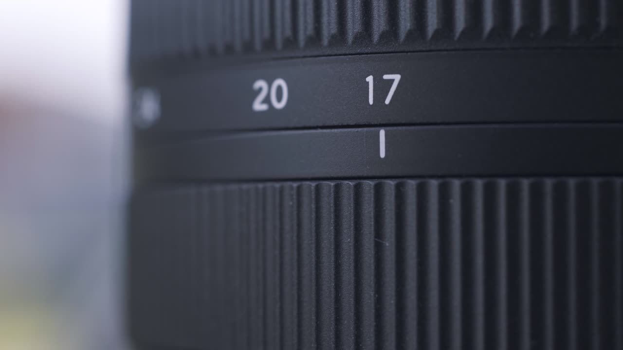Close up of zoom scale on black digital camera lens. Action. Close up of professional photographing equipment details on blurred background.