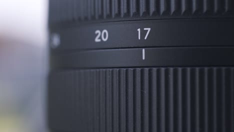 close up of zoom scale on black digital camera lens. action. close up of professional photographing equipment details on blurred background.