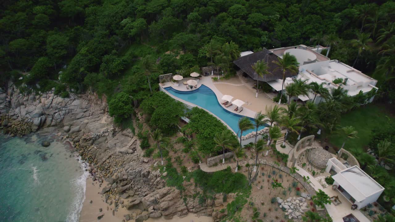 vista aérea de un hotel turístico tropical junto a la playa en huatulco