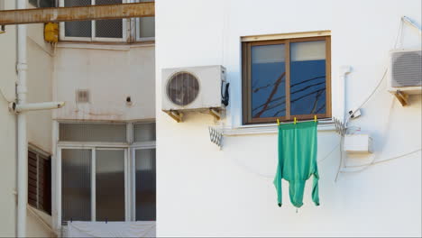 sweater hanging to dry against white wall